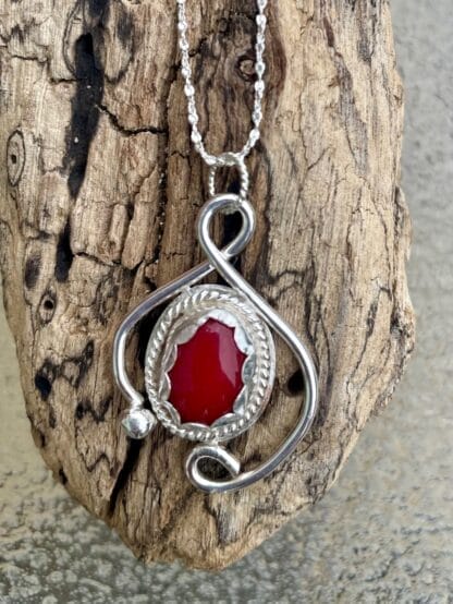 Carnelian silver necklace displayed on drift wood